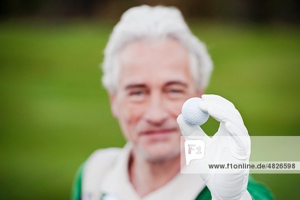 Italien  Kastelruth  Erwachsener Mann mit Golfball  lächelnd  Portrait