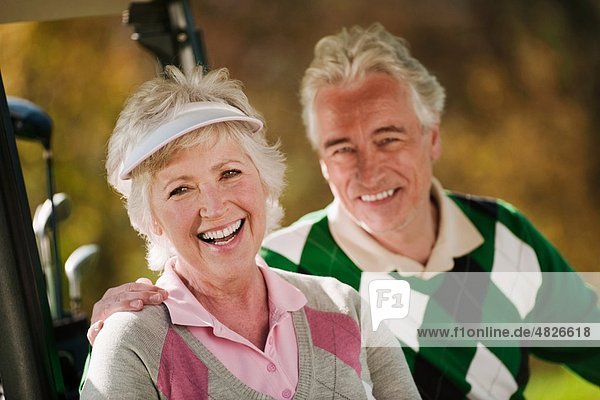 Italien  Kastelruth  Erwachsenes Paar im Golfwagen auf dem Golfplatz  lächelnd  Portrait