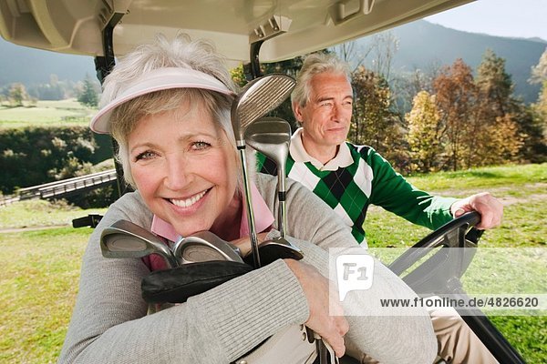Italien,  Kastelruth,  reifes Paar im Golfwagen auf dem Golfplatz