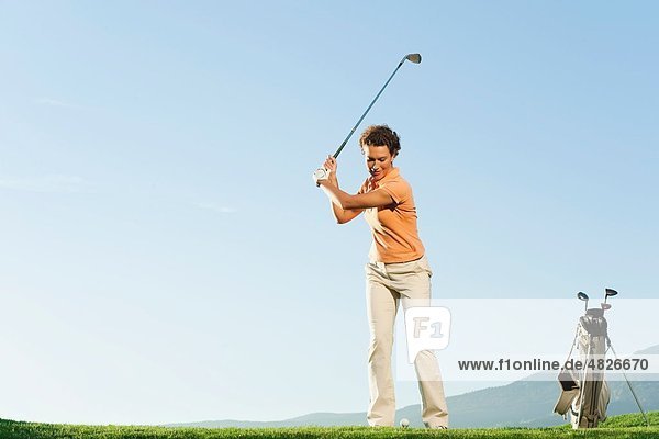 Italien  Kastelruth  Mittlere erwachsene Frau beim Golfen auf dem Golfplatz