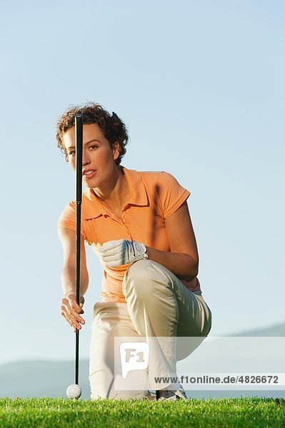 Italien,  Kastelruth,  Mittlere erwachsene Frau mit Golfschläger auf dem Golfplatz