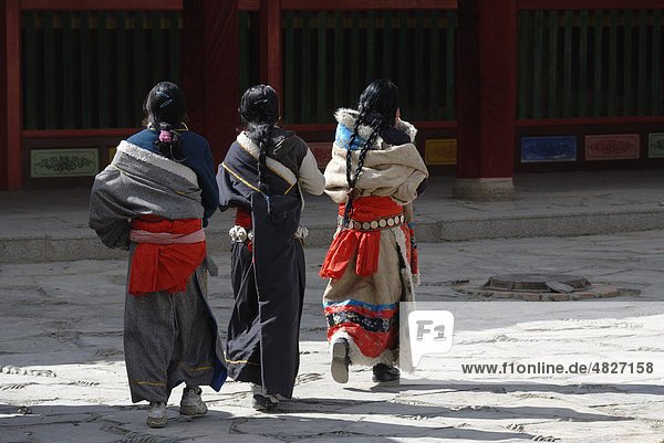 Tibetan women in traditional costume in front of the assembly hall or Dukhang  Labrang Monastery  Xiahe  Gansu  China  Asia