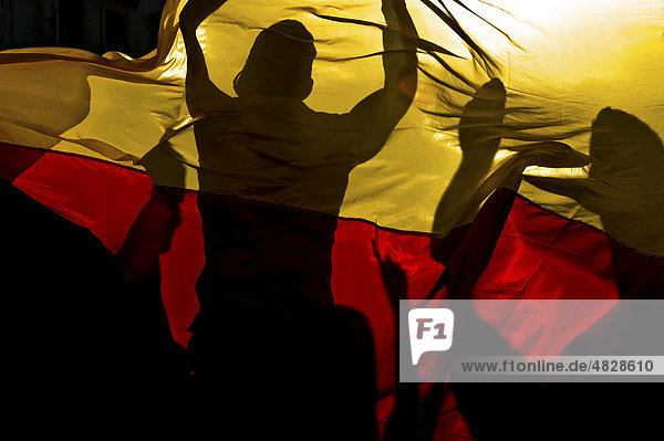 Deutsche Fußballfans feiern Sieg hinter Deutschlandfahne