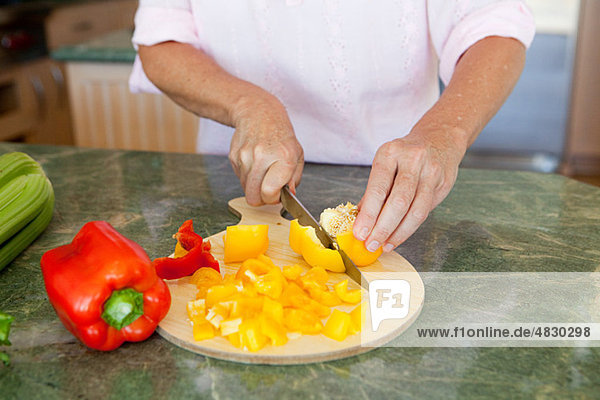 Woman chopping peppers on chopping board