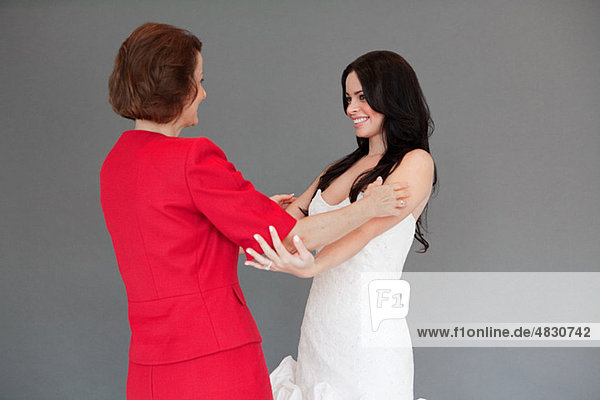 Tochter versuchen auf Hochzeitskleid  umarmen  Mutter