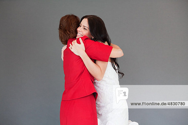Tochter versuchen auf Hochzeitskleid  umarmen  Mutter