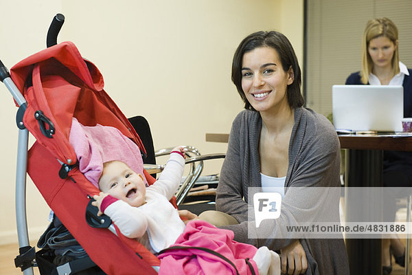 Mutter posiert mit Baby im Büro
