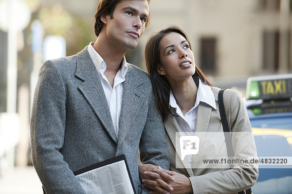 Couple standing outdoors  looking up in interest