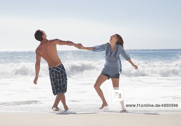 Fröhliches Paar Hand In Hand Am Strand Lizenzfreies Bild Bildagentur F1online 4850596 