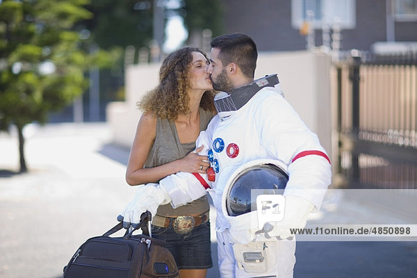 Frau küsst einen Astronauten