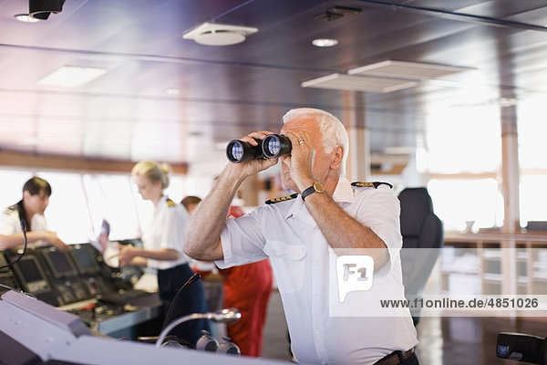 Kapitän auf dem Schiff mit Blick durch ein Teleskop