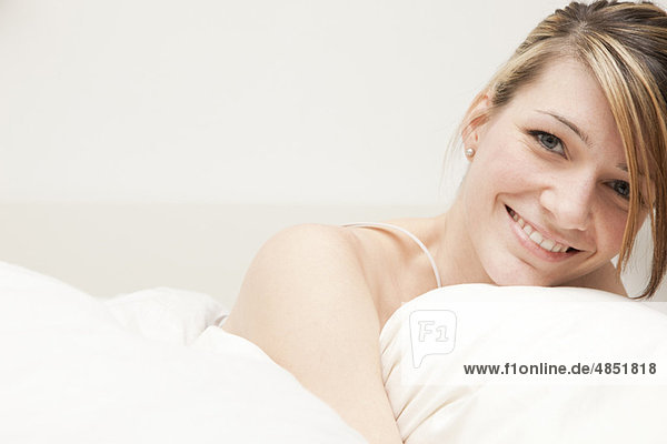 Porträt einer jungen Frau im Bett