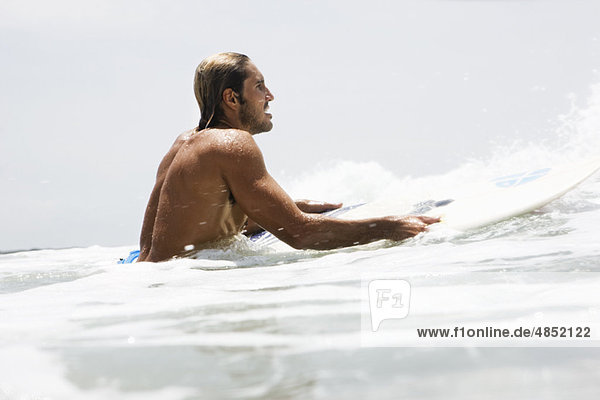 Der Typ auf dem Surfbrett wartet auf die Welle.