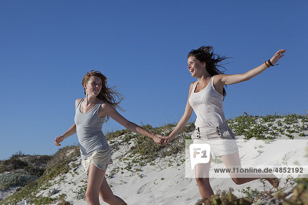 Two girls running down hill