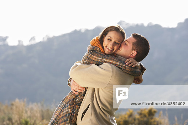 Junges Paar umarmt die ländliche Szene