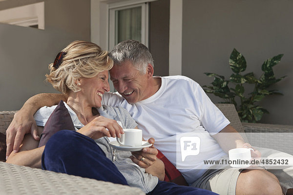 Mature couple drinking coffee on terrace