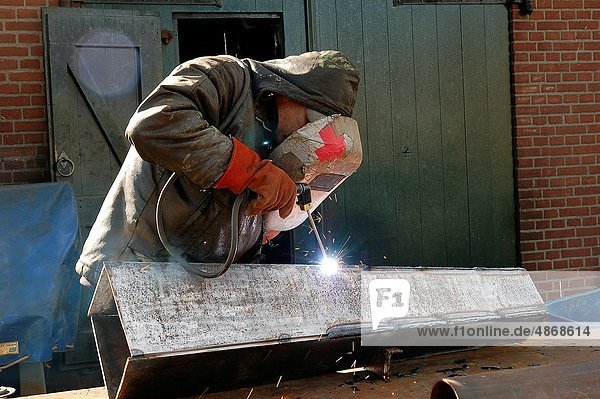 Rotterdam  Netherlands. A welder working on a piece of metal on a historical Rotterdam shipyard inside Old Harbour.