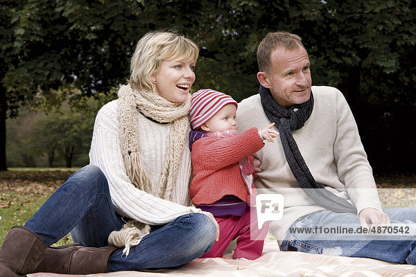 Familie mit einem Kleinkind entspannt im Park