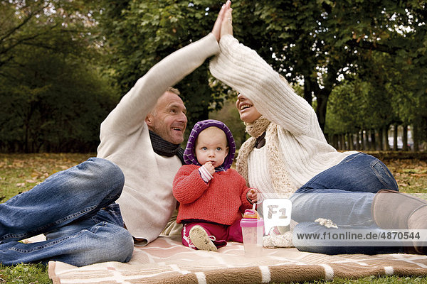 Familie mit einem Kleinkind entspannt im Park