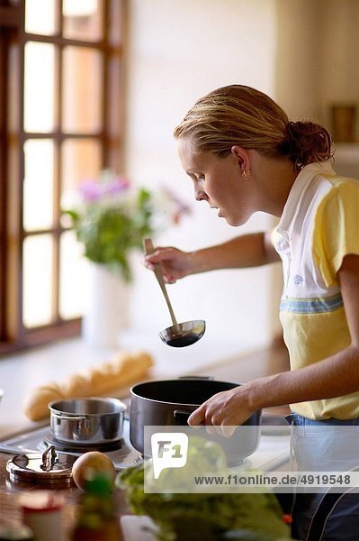 stehend kochen Frau Küche Löffel Verkostung Suppe