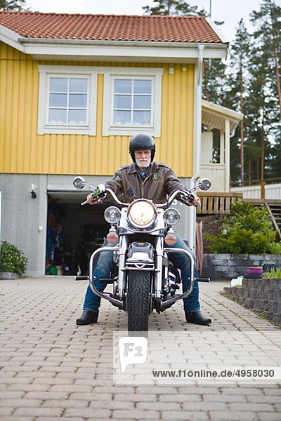 Mann auf dem Motorrad in Einfahrt vintage