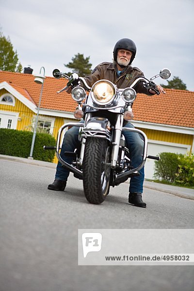 Senior man riding vintage motorbike