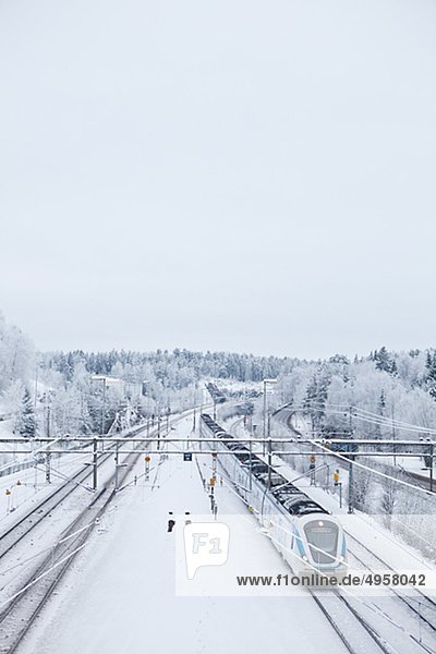 Personenzug auf Eisenbahnstrecke in Winter  erhöhte Ansicht