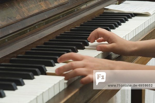 Mädchen beim Klavierspielen und Musizieren