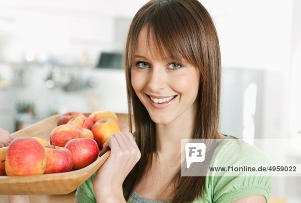 Frau hält Tablett mit Äpfeln