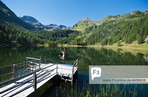 Österreich  Steiermark  Mittlere erwachsene Frau beim Sprung in den See duisitzkar in Schladming