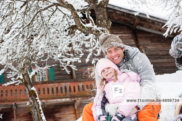 Österreich  Salzburg  Hüttau  Vater und Tochter vor dem Bauernhaus sitzend