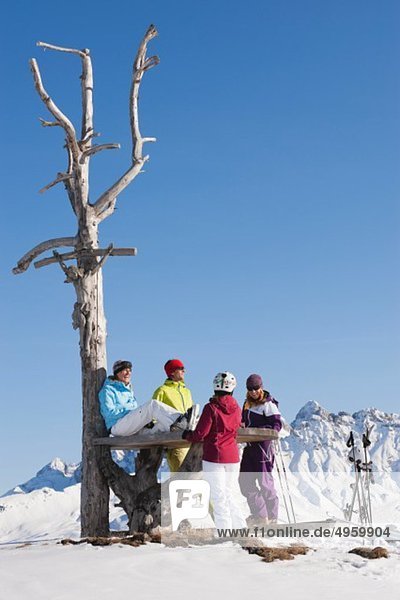 Italy  Trentino-Alto Adige  Alto Adige  Bolzano  Seiser Alm  People resting near bare tree on snowy landscape