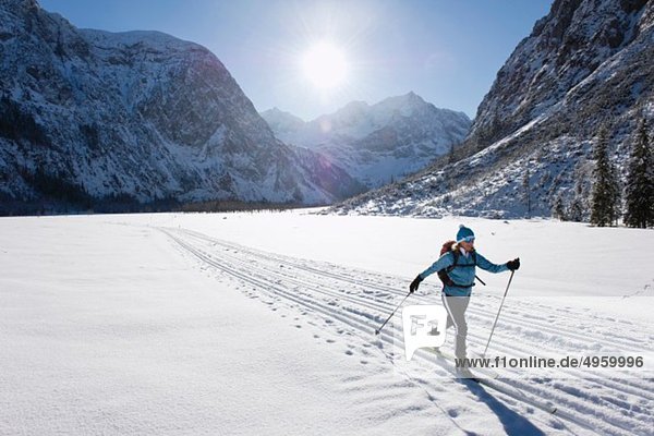 Seniorin beim Langlaufen mit Karwendalgebirge im Hintergrund
