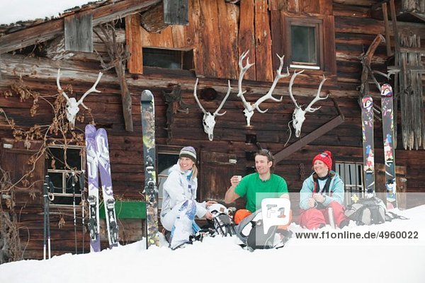 Österreich  Kleinwalsertal  Freunde sitzend bei der Berghütte