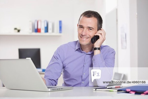 Germany Bavaria Munich Businessman on phone in office