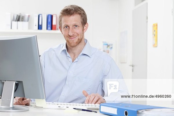 Germany  Bavaria  Munich  Businessman using computer  smiling  portrait