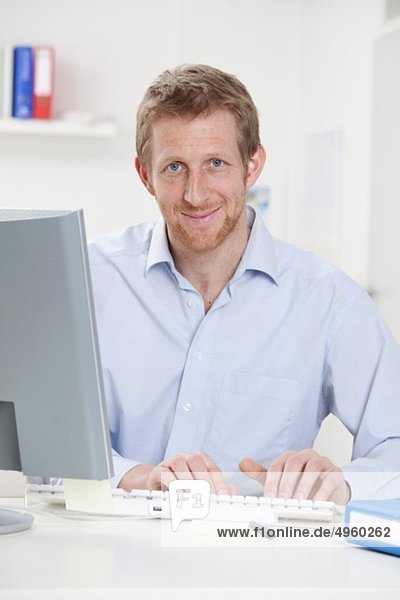 Germany  Bavaria  Munich  Businessman using computer  smiling  portrait