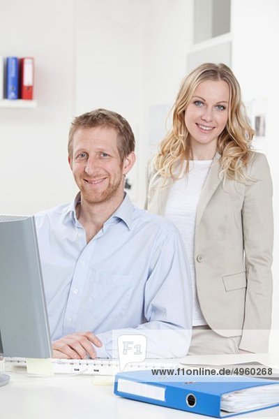 Geschäftsfrau und Geschäftsmann im Büro  lächelnd  Portrait