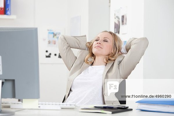 Geschäftsfrau entspannt im Büro  Augen geschlossen