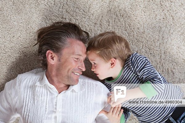 Germany  Bavaria  Munich  Father and son lying on floor