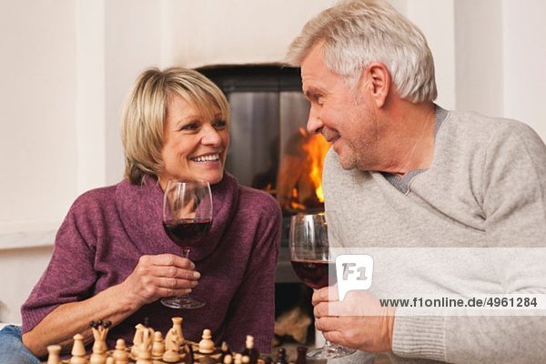 Deutschland  Kratzeburg  Seniorenpaar mit Weinglas und Schachbrett