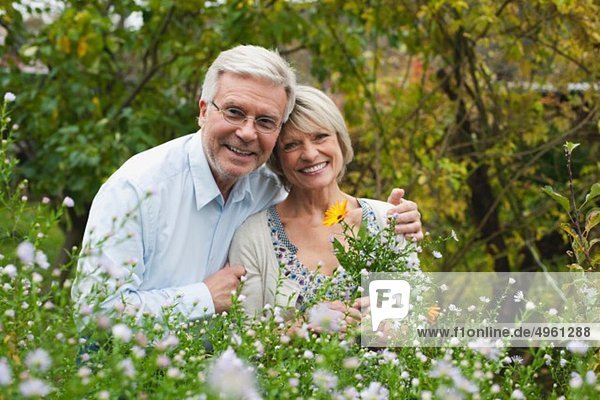 Deutschland  Kratzeburg  Seniorenpaar im Garten  lächelnd  Portrait