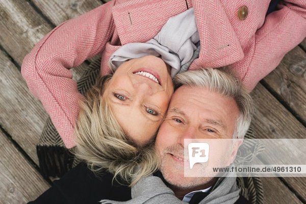 Deutschland  Kratzeburg  Seniorenpaar auf Strandpromenade liegend  lächelnd  Portrait