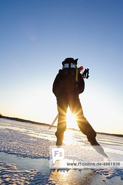 Mann Eislaufen auf Schnee bedeckt Landschaft