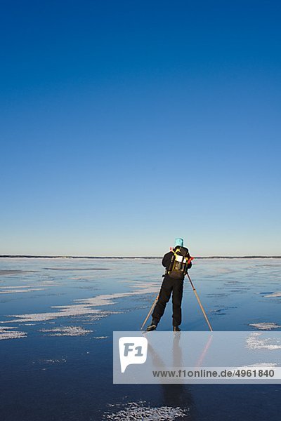Mann Eislaufen auf Schnee bedeckt Landschaft