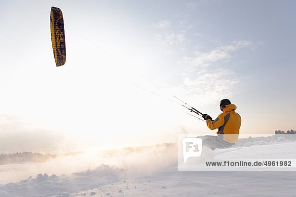 Mann Kiteboarding im Schnee