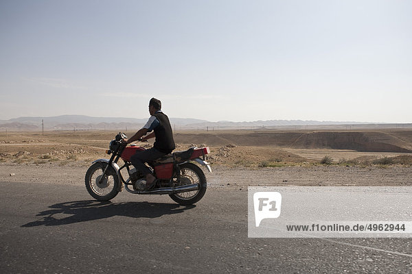 Usbekistan  Mann auf dem Motorrad entlang der ehemaligen Seidenstraße