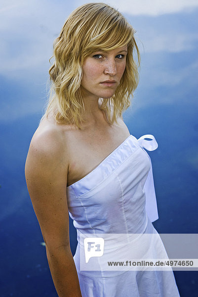 Young bond woman in white dress at a lake  Darmstadt  Hesse  Germany