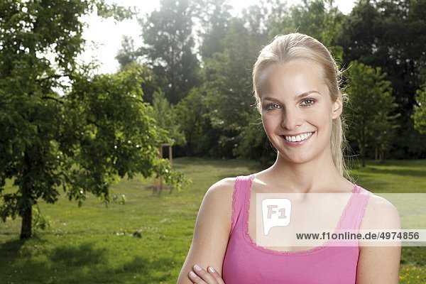 Blond young woman smiling in meadow
