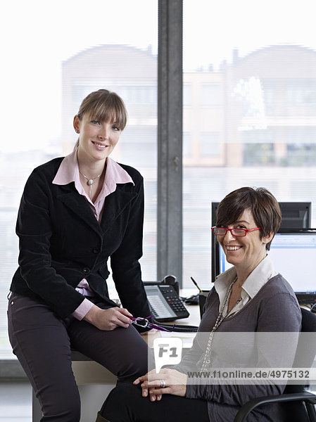 Two Women looking over some paper work in an Office